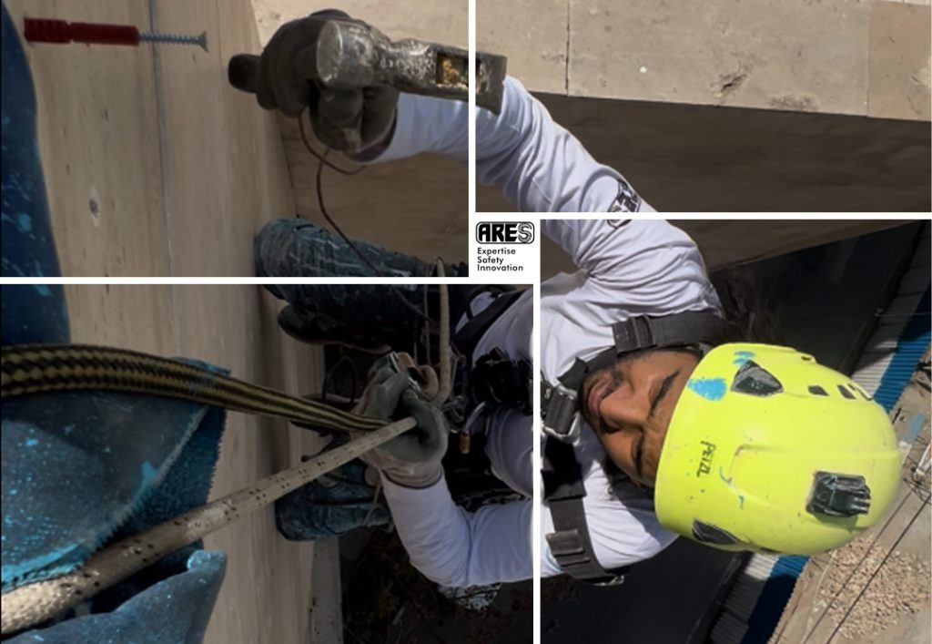 کارشناس شرکت آرس با استفاده از تکنیک دسترسی با طناب در حال بررسی دقیق سنگهای نمای ساختمان.